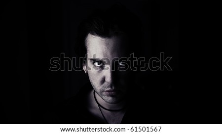 Low-key portrait of a man with a evil look on his face./ Man Glaring