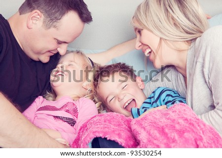 A family in bed laughing together.