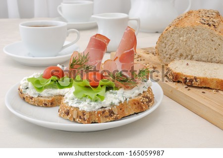 breakfast with a cup of coffee and a sandwich of whole grain bread with ricotta and ham