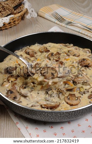Fried mushrooms in a creamy sauce cooked in a frying pan