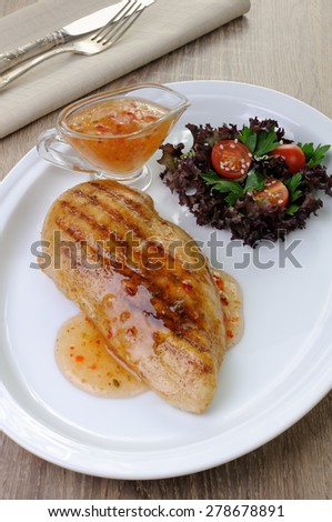 Chicken breast with sweet and sour sauce salad garnish on a plate
