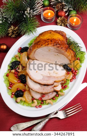 sliced baked turkey ham with fruit garnish on the Christmas table