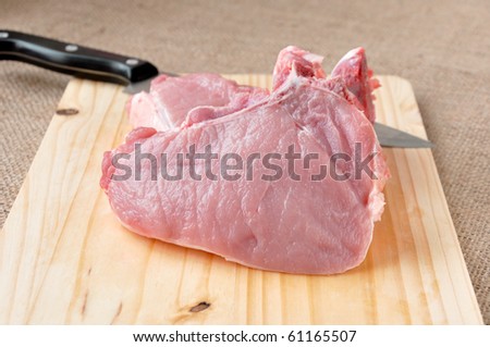 pieces of steak on the bone lying on a wooden board