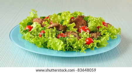 Salad of lettuce with cherry tomatoes and sesame seeds with chicken liver