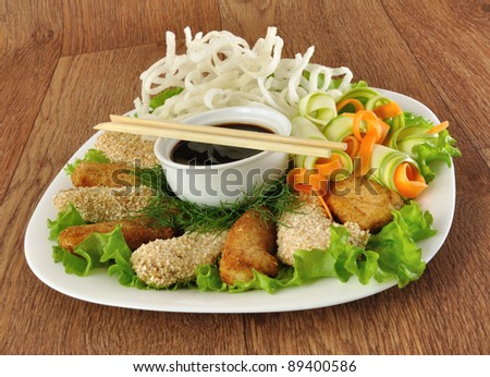 Chicken fillet in breadcrumbs and sesame with fried rice noodles with vegetables