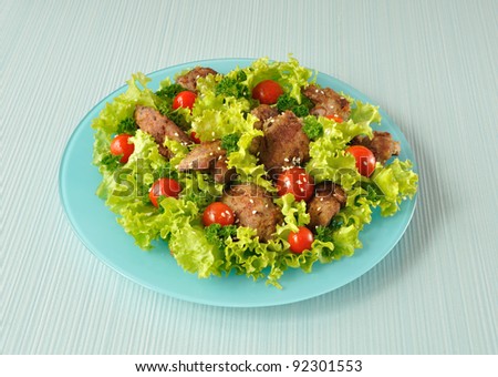 Salad of lettuce with cherry tomatoes and sesame seeds with chicken liver