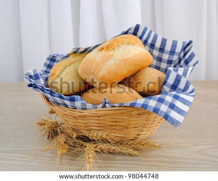Fresh bread in a basket with a cloth cover ears of wheat