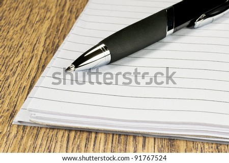 Pen and papers on wooden desk