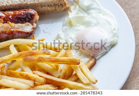 Sausage, egg and chips on a plate