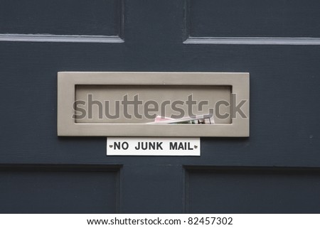 House letterbox with \'No junk mail\' sign and junk mail