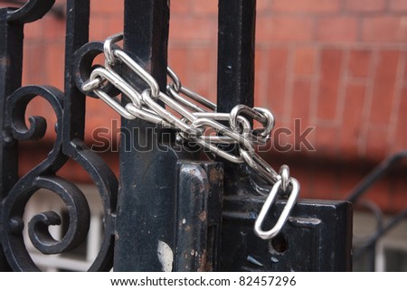 A chrome chained securely locked around a gate