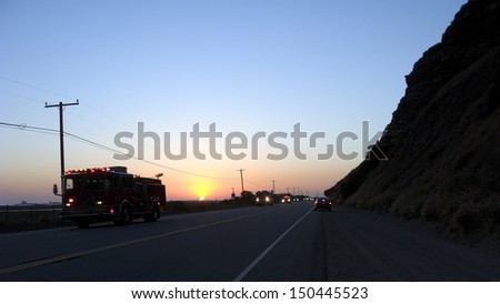 Fire Engines and Trucks rushing on Pacific Coast Highway in Ventura at dusk; California