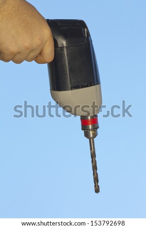 Portable Electric Drill with Long Bit in Operator Hand