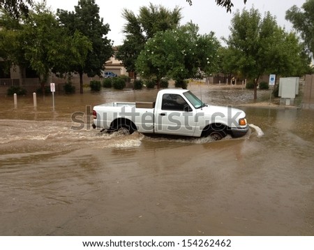 PHOENIX, US - SEPTEMBER 9, 2013: Truck slowly crossing flooded area of city street after heavy seasonal monsoon rain in Phoenix, Arizona