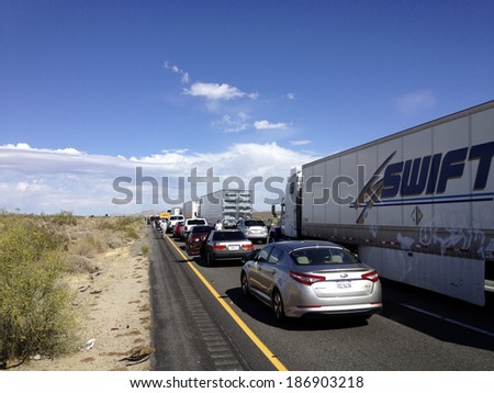 Chiriaco, CA - APRIL 11, 2014: People walking along idle cars and trucks on Interstate-10 in the middle of California desert
