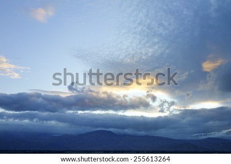 Winter weather system with rain clouds above Mojave desert south edge, Indio, California; backlit shot