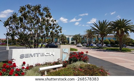 CAMARILLO, CA - APRIL 8, 2015: Semtech front sign and logo with red roses in foreground and magnolia tree, palms and main road to the corporate headquarter office in Camarillo, California