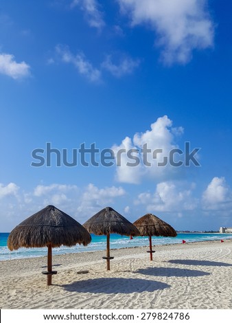 Beach umbrellas along Caribbean sea coast, Cancun on rare cloudy day