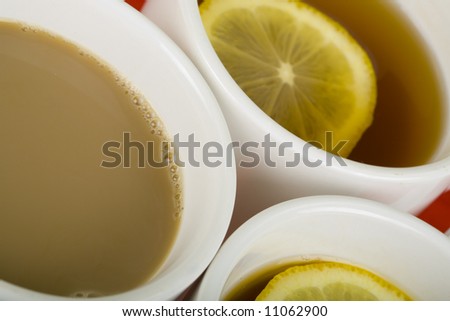 Caps of fresh coffee and tea with lemon background; close up