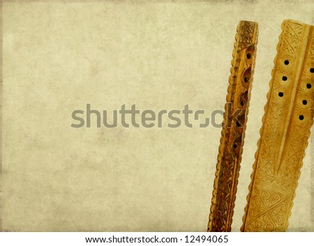 brown background image, with close-up of a two wooden flutes and plenty of space for text