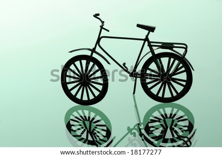 lovely image of a bicycle and its reflection against light green background