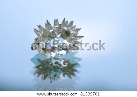 glass hedgehog on reflective surface (shallow depth of field)