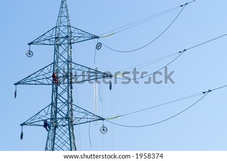 Two workers connecting wires on electrical pylone