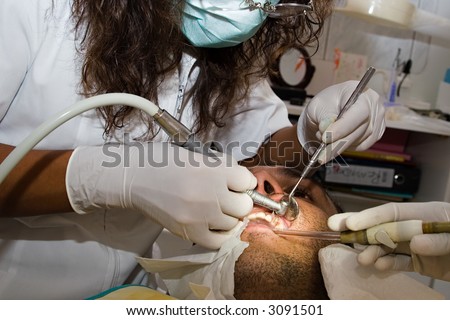 Female dentist, with Caucasian patient, working to replace a tooth, health series