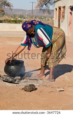 Three legged pot with traditional African food , setswa, African adult woman , people diversity series