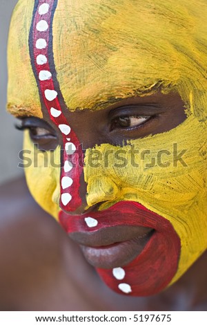 Young African girl, tribal painted face in yellow and red