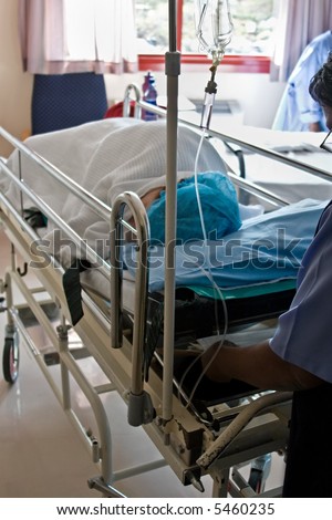 Healthcare personnel carry one patient after surgery in the recovery room