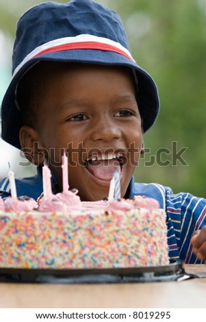 African American boy next to his birthday cake