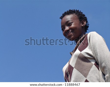 Young African girl against the blue sky dressed with a jersey