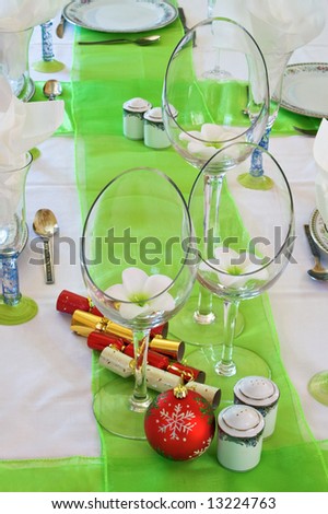 Table decorated in the Christmas spirit with crackers and globes.