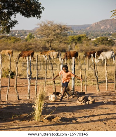 African child playing football at the cattle post