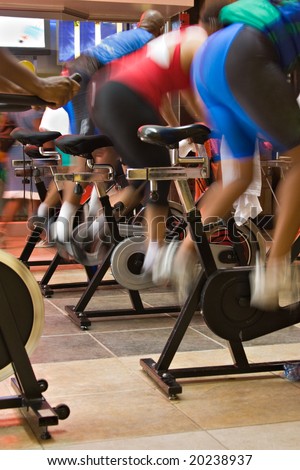 blur motion of group of people having a training session on spin bikes