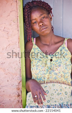 african woman standing in front of the door , village in Botswana