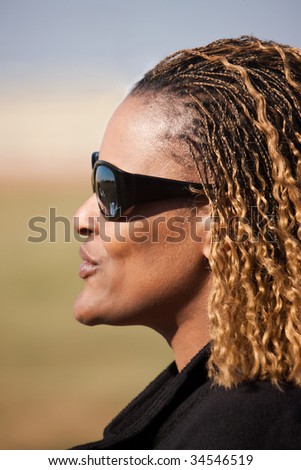 lifestyle portrait of an African middle age woman outdoors in the park