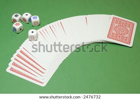 Poker dices and a cards deck on a casino table background