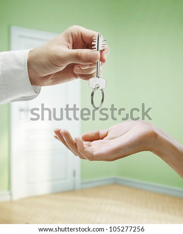 key in hands, background of green room
