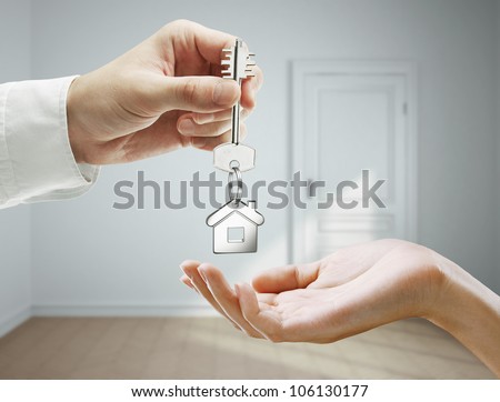 passing keys against backdrop of gray room