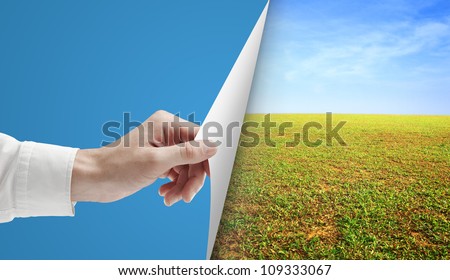 hand turns blue page in field