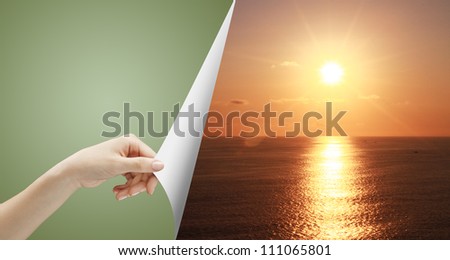 hand turn green page to sunset over ocean