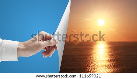 hand turn gray page to sunset over ocean