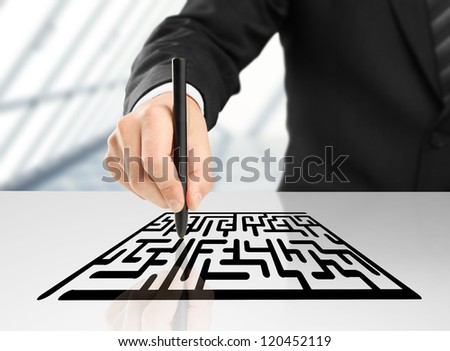 businessman drawing labyrinth on a white background