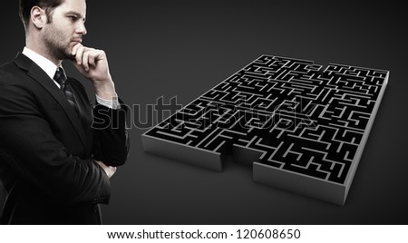 man looking at black labyrinth  on black background