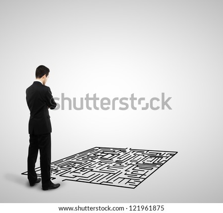 businessman looking at labyrinth on a white background