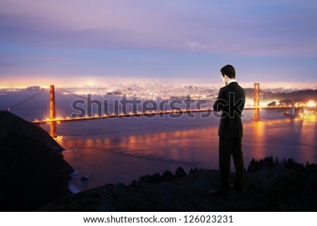 man standing on pier and looking city at night