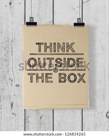 poster with think outside the box on a wood wall