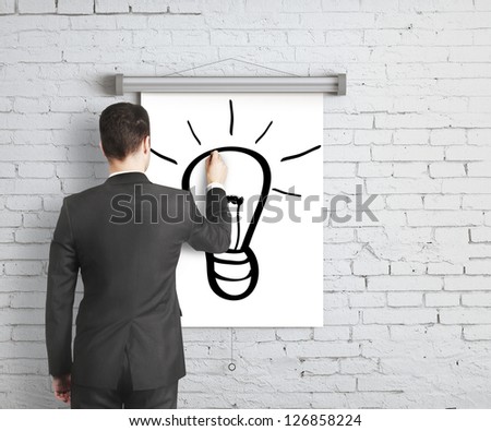 businessman drawing lamp on poster